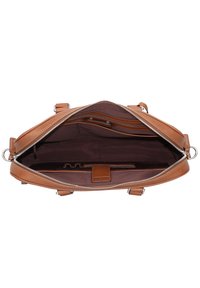 Brown leather handbag with a zip closure. Interior features a dark fabric lining, and multiple pockets for organization.