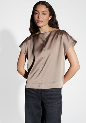 Top a maniche corte in satin taupe, caratterizzato da una vestibilità ampia e una forma boxy. Tessuto liscio con un design pulito e minimalista. Look casual abbinato a jeans scuri.
