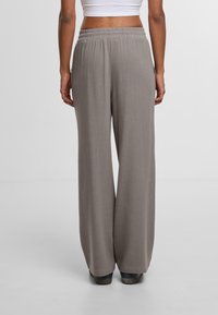 Grijze broek met wijde pijpen en een elastische tailleband, gemaakt van zachte stof, met een gladde textuur en een volledig ontworpen lengte.