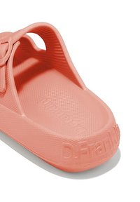Sandalia tipo slip-on de color coral con una superficie texturizada y marca en relieve. Diseñada para la comodidad, con laterales abiertos y suela plana.