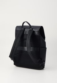 Black backpack with a textured finish, mesh back panel, adjustable padded straps, and a top handle for easy carrying.
