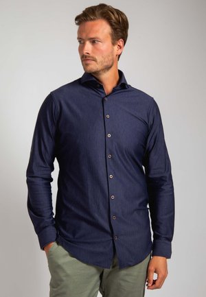 Marineblauwe button-up shirt van gestructureerde stof, met een kraag, lange mouwen en bruine knopen aan de voorkant.