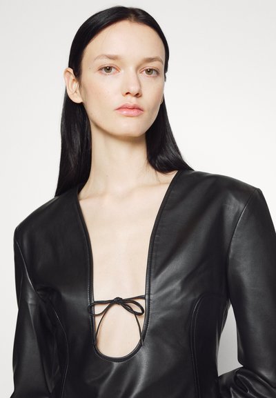 Čierny kožený body s hlbokým V-výstrihom a centrálnym viazaním. Hladká textúra, priliehavý strih a minimálne švy.