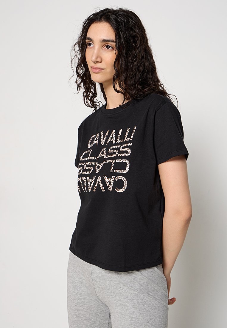 T-shirt in cotone nero con una grafica audace e verticale in motivo leopardato, maniche corte e vestibilità rilassata.