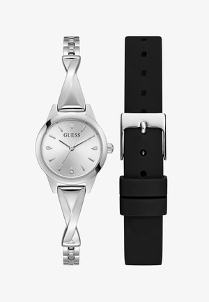 Relógio de pulso Guess prateado, com uma bracelete de metal torcido e uma correia de silicone preta separada com um fecho prateado.