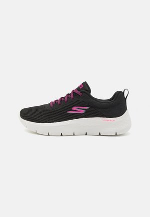 Black athletic shoes with a mesh upper, pink laces and accents, thick white midsole, and textured outsole for grip.