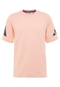Camiseta de color rosa claro con cuello redondo, mangas raglán cortas y diseños de acento negro en las mangas. Fabricada con tela suave y transpirable.
