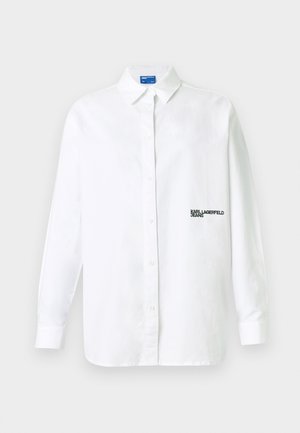 Fehér, hosszú ujjú, gombos ing gallérral és a bal mellrészen fekete "KARL LAGERFELD JEANS" feliratos logóval.