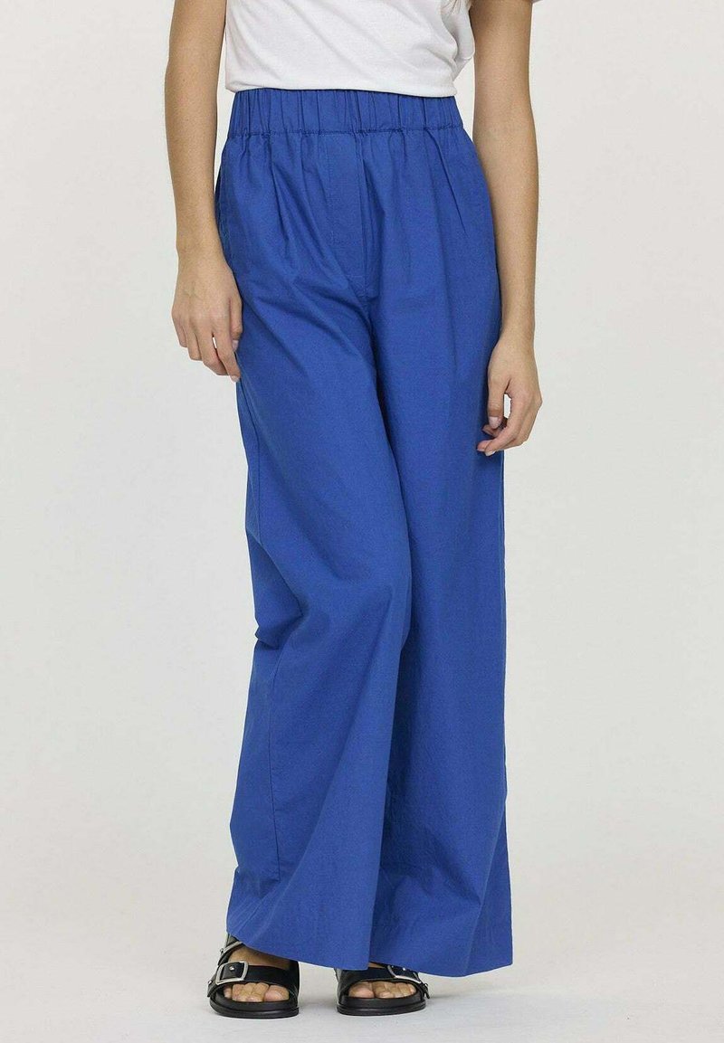 Pantalons larges bleus avec une taille élastique, fabriqués à partir d'un tissu léger, offrant une texture lisse et une coupe décontractée.