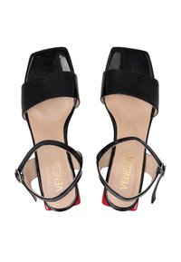 Schwarze patentlederne High-Heel-Sandalen mit quadratischen Zehen, breiten Riemen und dünnen Knöchelriemen. Mit einem kontrastierenden roten Absatz.