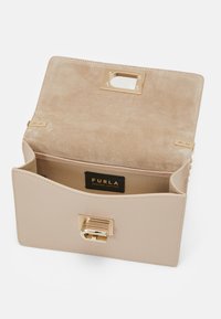 Borsa a tracolla in pelle beige con interno in camoscio, hardware dorato e chiusura a scatto, dotata di una texture liscia e un compartimento principale.