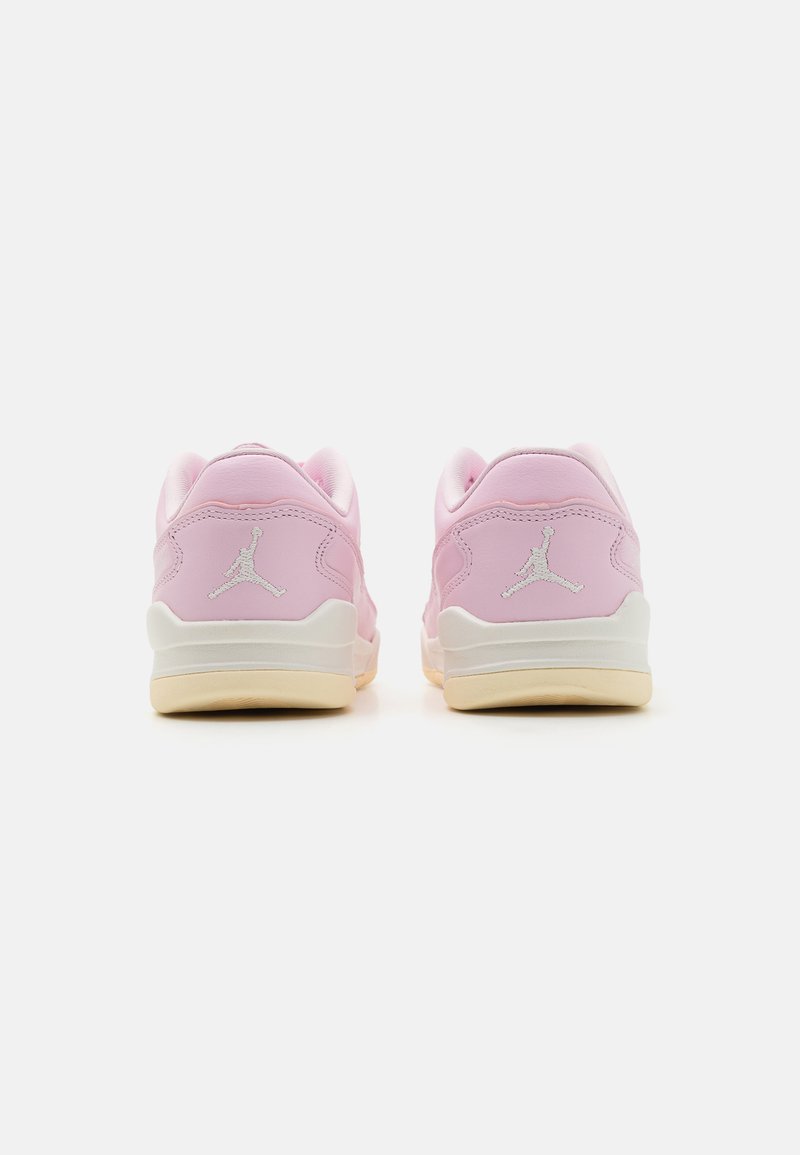 Baskets en cuir rose avec accents blancs, présentant une forme arrondie, un col rembourré et le logo Jordan sur le talon. Semelle extérieure en caoutchouc visible.