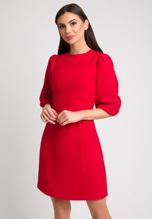 Czerwona sukienka z okrągłym dekoltem, krótkimi bufiaste rękawami i dopasowaną talią. Gładki materiał z długością do kolan. Prosty, elegancki design.