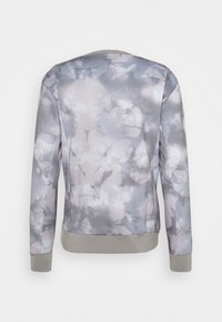 Sudadera ligera en un patrón de acuarela en gris y blanco. Cuenta con mangas largas y un dobladillo acanalado. Textura suave con un corte relajado.