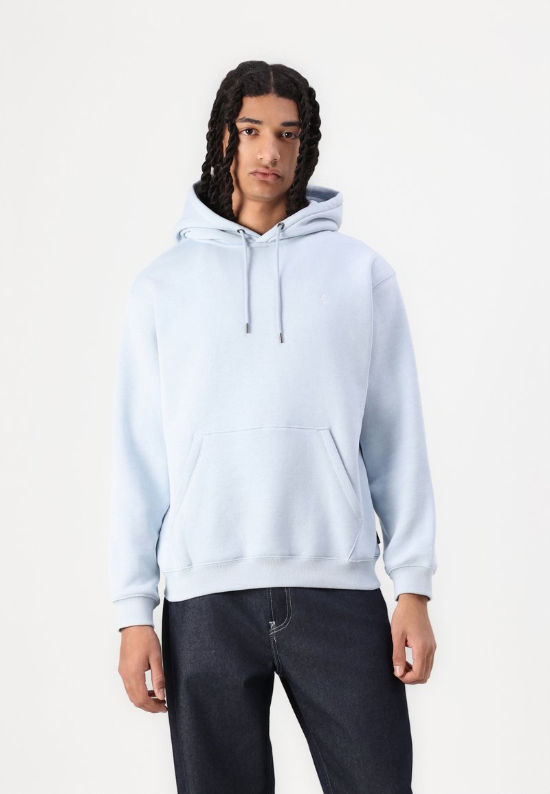 Hellblauer Hoodie aus weichem Stoff, mit einer Kängurutasche, Zugbändern sowie gerippten Bündchen und Saum. Trägt er mit dunklen Jeans.
