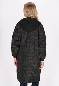 Palton lung, de tip lejer, cu imprimeu de camuflaj în verde închis și negru, cu glugă, manșete elastice și o textură netedă, strălucitoare.