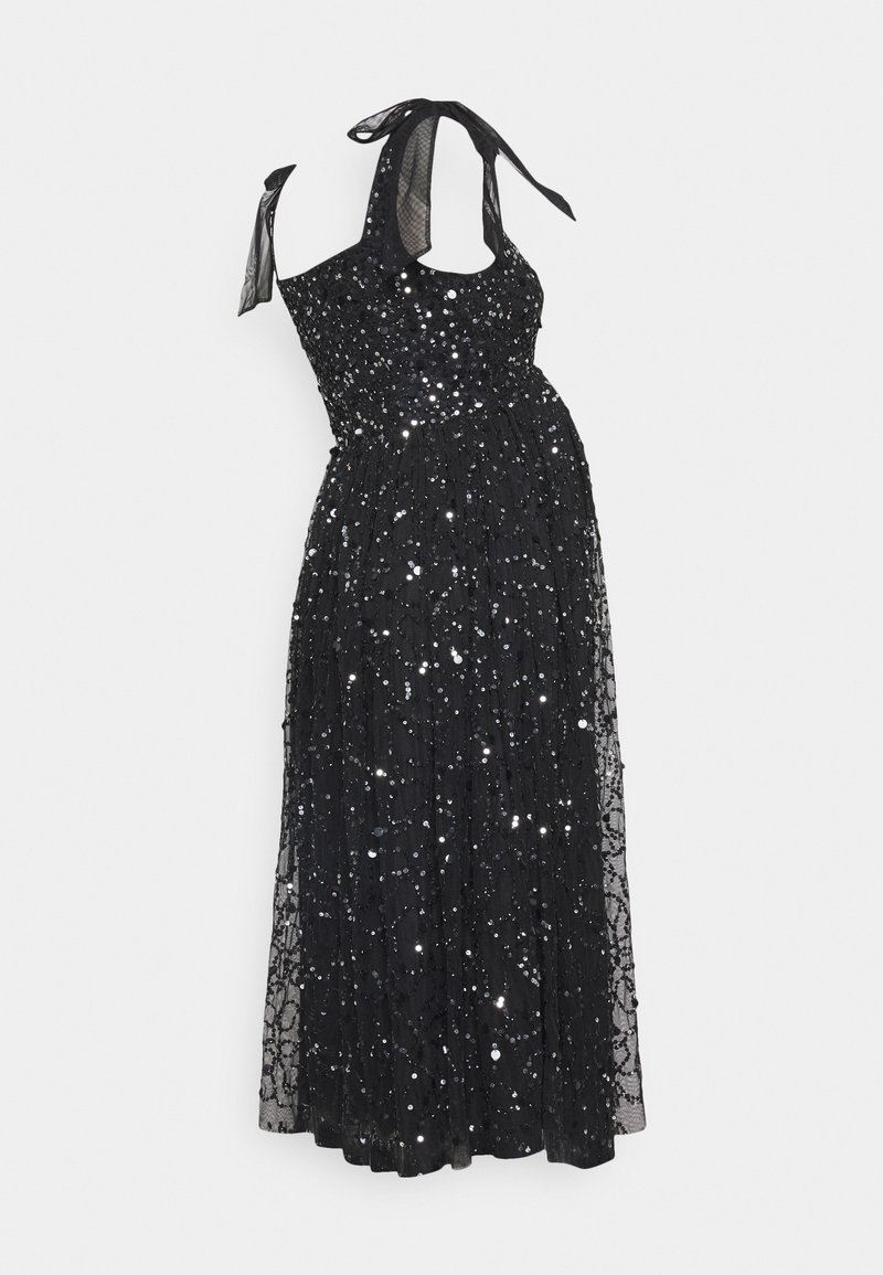 Robe maxi noire en sequins avec un corsage ajusté, une superposition transparente et des nouettes au cou. Elle présente une jupe fluide et des motifs complexes de sequins.