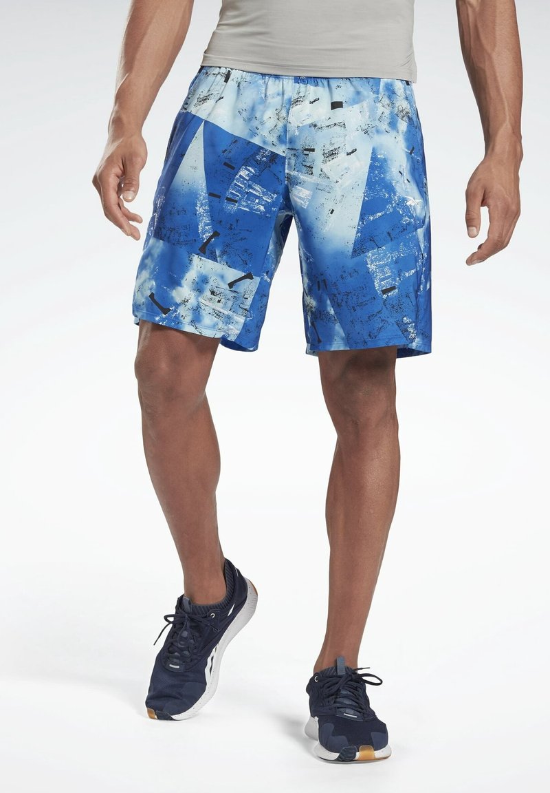 Shorts de sport bleus avec un motif géométrique, présentant des nuances de bleu clair et foncé, une taille élastique et une texture de tissu lisse.