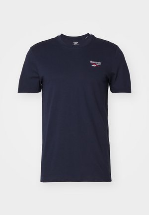 T-shirt bleu marine à manches courtes en coton, avec un petit logo Reebok en blanc et rouge sur la zone gauche de la poitrine. Encolure ronde classique.