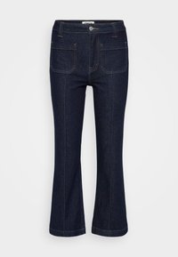 Mörkblå denimjeans med framfickor, kontrasterande sömmar, bältesloopar, knäppning och något utsvängda ben.