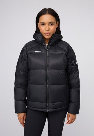 Zwarte pufferjas met capuchon, voorzien van horizontale quilt, een volledige ritssluiting, zijzakken en het merkembleem op de borst en mouw.