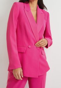 Blazer doppiopetto fucsia con revers a incavo, tasche frontali e dettagli con bottoni, realizzato in tessuto liscio e strutturato.