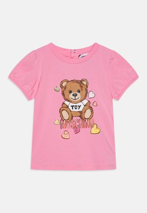 Różowy t-shirt z krótkim rękawem, z grafiką misia i napisem "TOY", otoczony kolorowymi sercami. Wykonany z miękkiej bawełny.