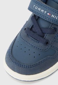 Blå lær- og semsket sneakers med en teksturert overflate, perforert tåboks og borrelås. Har hvit gummisåle og marineblå lisser.
