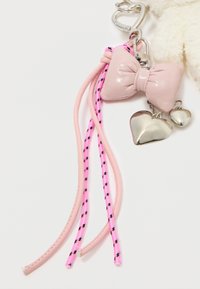 Rózsaszín, fényes bow charm ezüst szív díszítéssel, egy fonott rózsaszín és fekete zsinórra erősítve, ezüst kulcstartóval. Texturált és fényes felület.