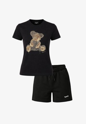T-shirt nera a maniche corte con una grafica testurizzata di un orsetto, abbinata a pantaloncini neri a vita elastica con un piccolo logo bianco.