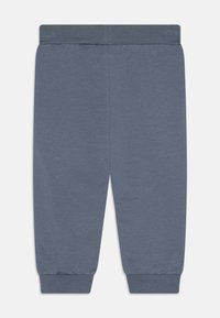 Graue Baumwoll-Sweatpants mit elastischem Bund und Bündchen, die eine glatte Textur und ein schlichtes Design ohne Muster oder Details aufweisen.