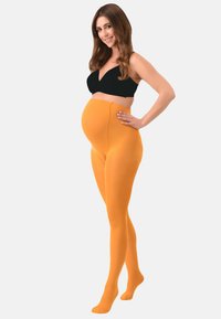 Collant pre-maman di un vivace colore arancione, realizzati in un tessuto liscio e elasticizzato, che si adattano comodamente alla pancia con un alto elastico in vita.