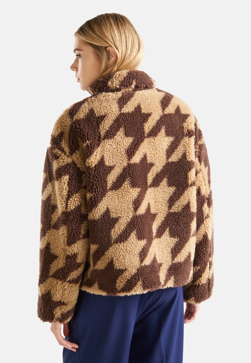Jacke aus fuzzy Fleece mit Hahnentrittmuster, in Beige und Braun, mit hohem Kragen und langen Ärmeln, die eine weiche Textur und eine lockere Passform bietet.