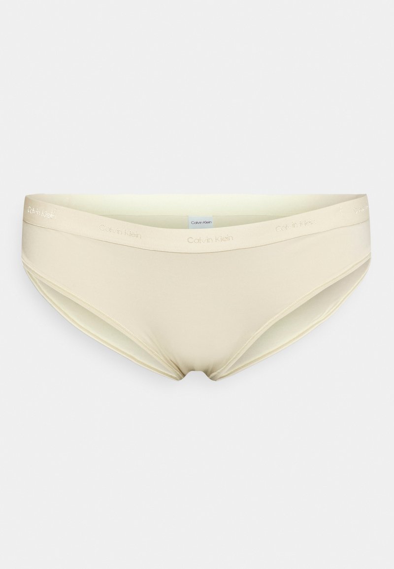 Cuecas de bikini em mistura de algodão bege com uma textura suave e uma faixa elástica na cintura, apresentando o logótipo "Calvin Klein" em letras subtis.