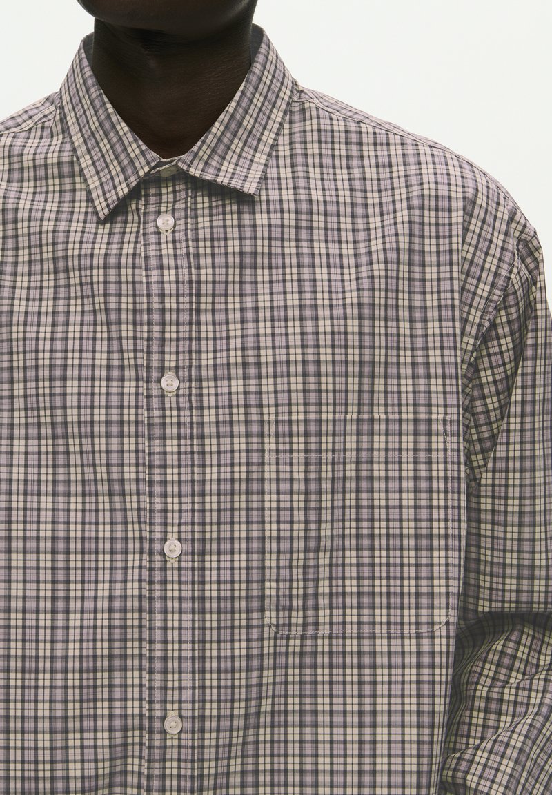 Camicia con bottoni realizzata in tessuto leggero, caratterizzata da un motivo a scacchi nelle tonalità di viola, grigio e crema, con colletto classico e taschino.