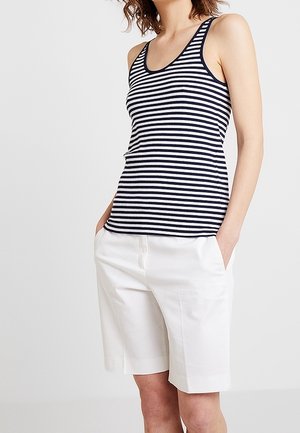 Granatowo-biały top na ramiączkach w paski z okrągłym dekoltem i szerokimi ramiączkami, zestawiony z białymi, dopasowanymi szortami z bocznymi kieszeniami.