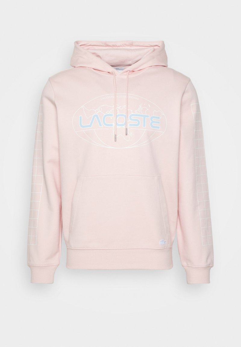 Sweat à capuche rose clair avec poche avant, logo Lacoste bleu et graphique de carte du monde sur la poitrine, et motif à carreaux sur les manches.