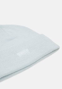 Jasnoniebieska dziana czapka z mankietem, z subtelną białą naszywką z logo Levi's z boku. Miękka w dotyku i prążkowana.