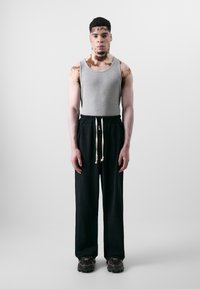 Gray tank top, black sweatpants with elastic waistband and white drawstring, and chunky black shoes. Smooth texture, relaxed fit.
