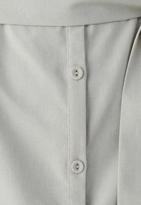 Light gray fabric with a textured finish featuring two gray buttons along the center. Simple, vertical design with a clean, minimal look.