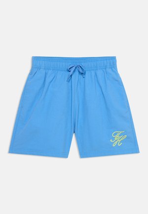 Μπλε σορτς με ελαστική μέση και κορδόνι, με κίτρινα κεντημένα αρχικά "TH" στο κάτω δεξί πόδι.