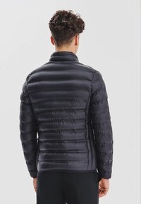 Czarna kurtka puchowa z pikowanym wzorem, lekkim materiałem, wysokim kołnierzem oraz dopasowanym krojem z poziomymi przeszyciami.