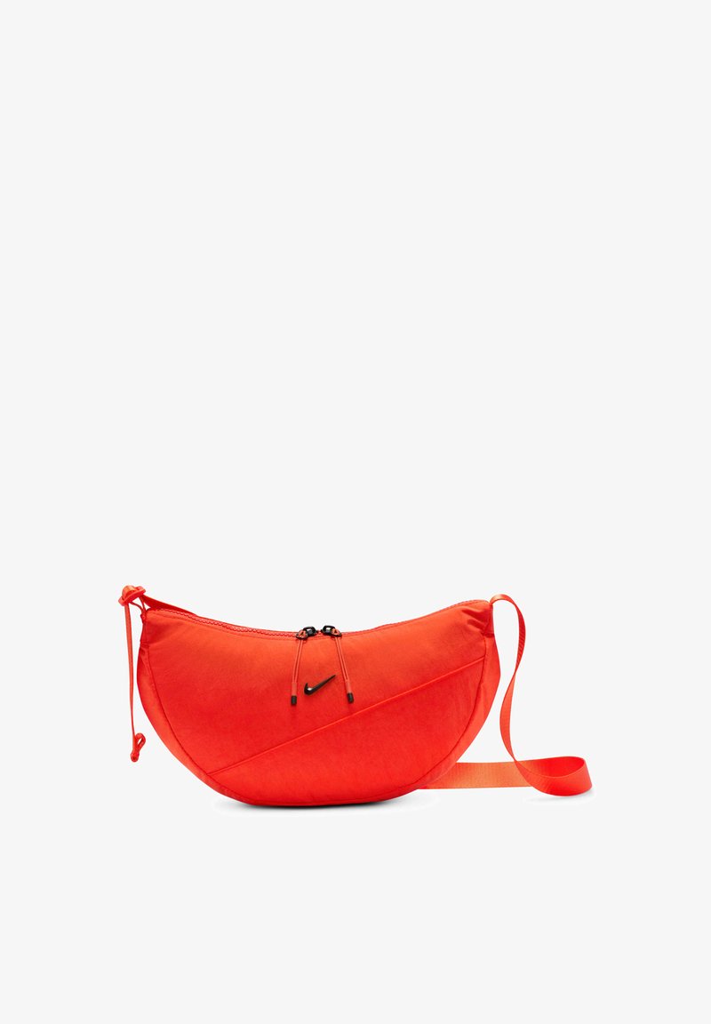 Κόκκινη νάιλον τσάντα x-body με καμπυλωτό σχήμα, που διαθέτει διπλό κλείσιμο με κορδόνια, μαύρη λογότυπη λεπτομέρεια και ρυθμιζόμενο λουρί.