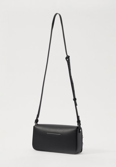 Borsa a tracolla nera in pelle con forma rettangolare, tracolla regolabile e un dettaglio cucito minimalista sulla parte anteriore.