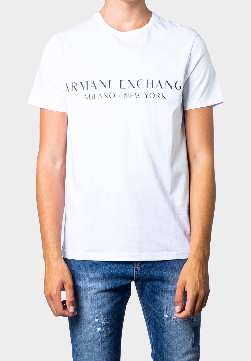 Bílá bavlněná tričko s potiskem "ARMANI EXCHANGE MILANO / NEW YORK" v černé barvě, kulatý výstřih, krátké rukávy, přiléhavý střih.