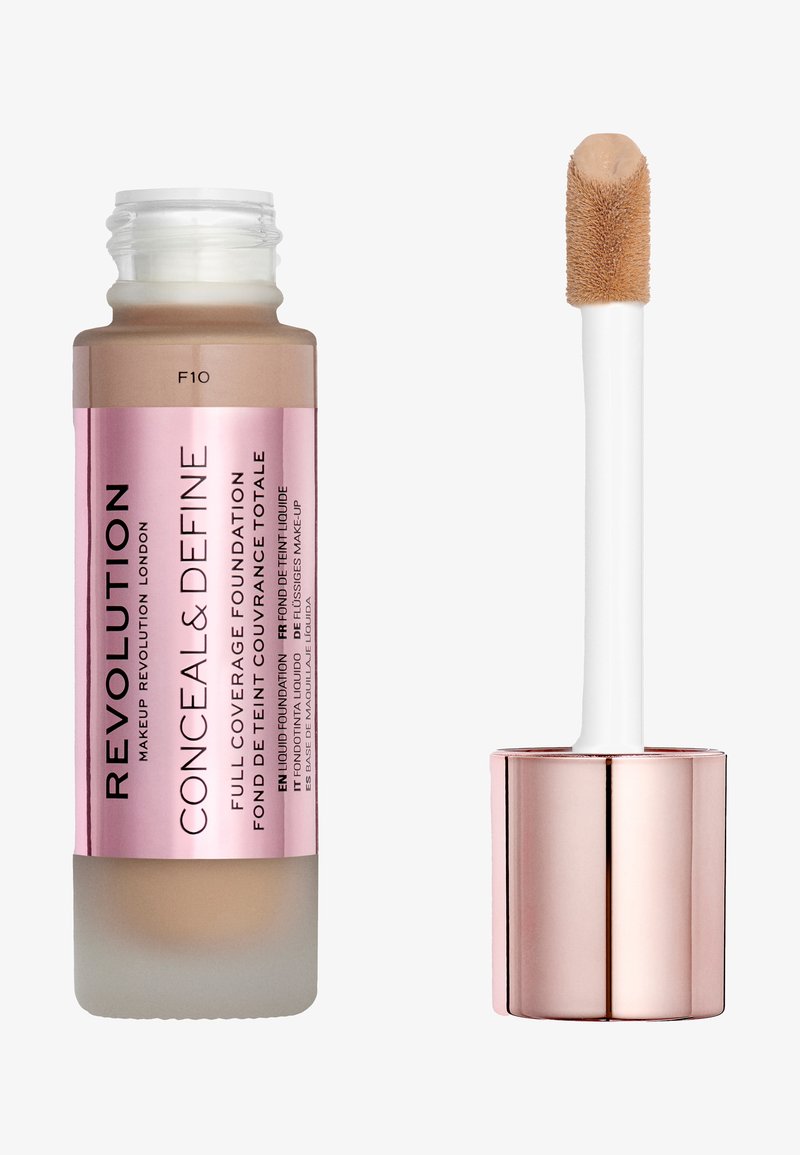 Fuld dækning foundation i en frostet glasflaske med en pink etiket, der har en hvid applikator med en fuzzy spids. Farveskygge F10.