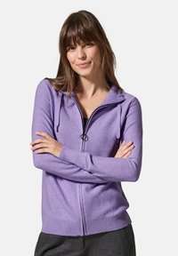 Hoodie zippé violet avec une finition texturée, doté d'une capuche, d'une fermeture éclair à l'avant et de poignets et d'un ourlet côtelés. Design uni sans logos visibles.