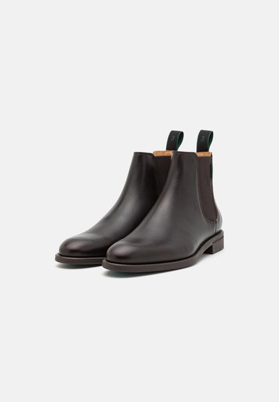 Brune lær Chelsea-støvler med elastiske sidepaneler, rund tå og grønne hørgreb. Minimalistisk design med en lav blokhæl.