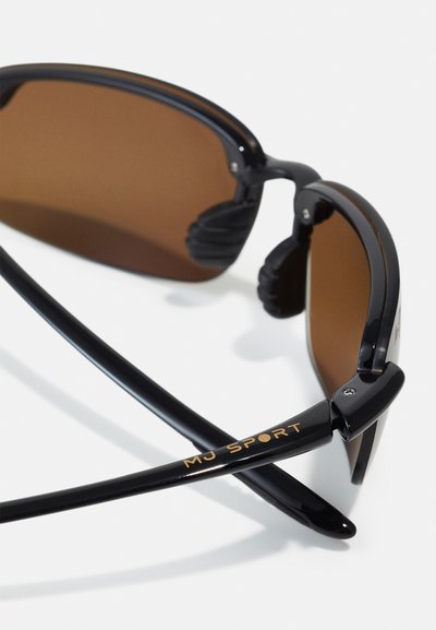 Occhiali sportivi neri con lenti marrone scuro, caratterizzati da un design elegante, impugnature in gomma sulle tempie e il logo "MJ SPORT" in oro sulla stanghetta.