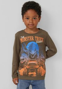 Olijfgroene longsleeve shirt met een graphic van dinosaurussen en een monstertruck in oranje en blauw. Zachte katoenen textuur.